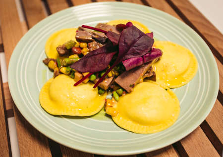 Ravioli with meat and vegetables on rustical plate and wooden table. Italian pasta - food concept.の写真素材