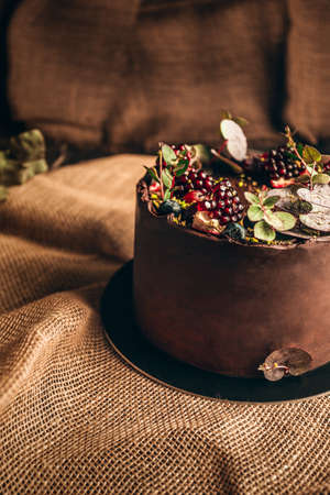 Beautiful brown cake from baker on dark background. Slice of cake. Chocolate and strawberry cake. Dessert on Birthday party. Delicious dessert - rustic and vintage style.の写真素材
