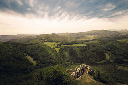 Beautiful scenic view of valley and big hills (mountains) in Slovakia on sunset with cloudy sky. Perfect panorama view on meadow and hills on sunset - summertime photo. Hills of Vapec - Slovakia.の写真素材