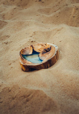 Handmade wooden bowl with blue epoxy in the nature (desert).の写真素材