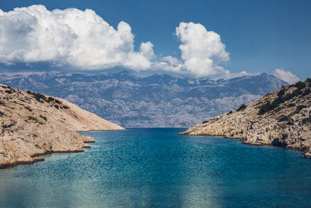 Mediterranean seascape in summer at sunny day with mountains and clouds on background - Croatia (Pag island). Wide view of beautiful bay with hills and crystal blue sea water.の写真素材