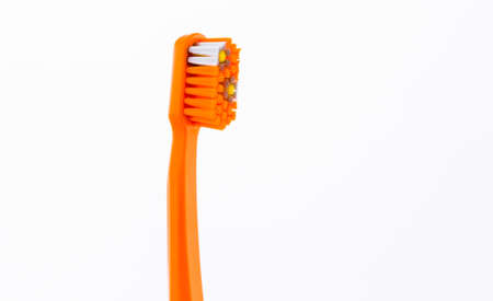 Orange plastic toothbrush with ultra soft bristles isolated on white background.の写真素材