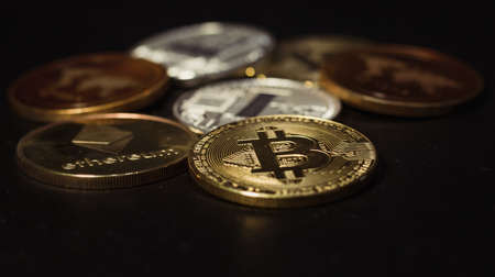 Family of cryptocurrency. Stack of shining golden and silver coins on dark black background. Crypto group. Shot of Ripple, bitcoin, litecoin and etherum. Symbols of crypto currency coins.の写真素材