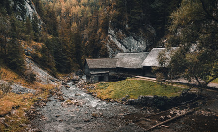 Photo of a beautiful wooden cabin with river in the forest from above - Mlyny Oblazy (Slovakia) -...