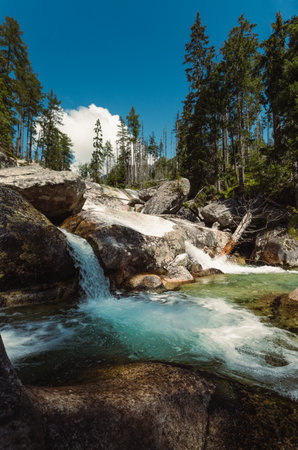 Waterfalls of cold creek in High Tatras National park. Mountain river  with crystal clear water in beautiful sunny day.の写真素材