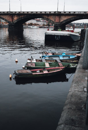 Photo of boats on the Vltava river in Prague Czechia at the evening. Colorful vessels on the river in city - dark urban photo.の写真素材