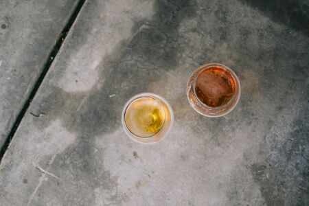 Two pints of beer sitting side by side on brewery floor