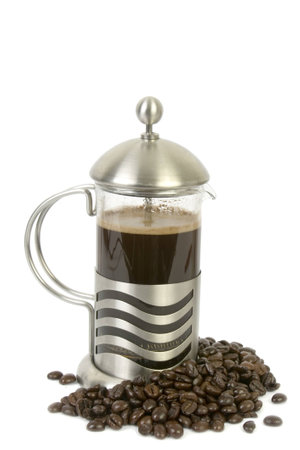 French press isolated on white with coffee beans underneathの写真素材