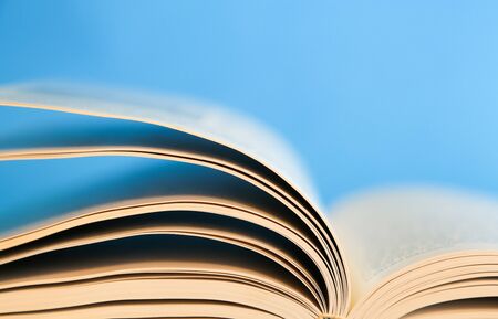 Book over a blue background with pages turning.