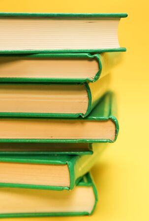 Book pile, over a yellow background - Education books backgroundの写真素材