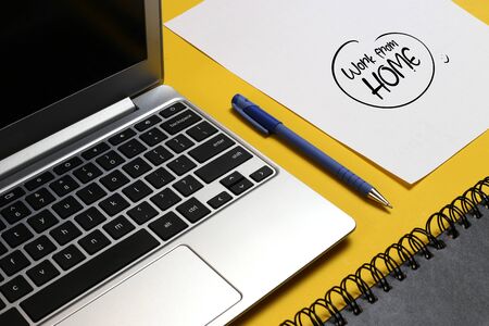 working form home text, laptop pen and notebook with work from home written on the paper.の写真素材