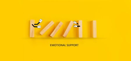 Emotional support concept. Bully pushed a domino with another holding arms open for emotional support.の写真素材