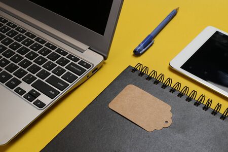 Laptop and tag. home office laid out with open laptopの写真素材
