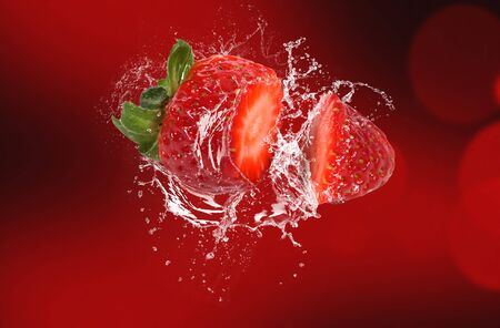 splashing cut strawberry on background. Water splash strawberry.の写真素材