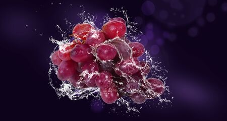 Bunch of grapes with water splashing around the grape bunchの写真素材