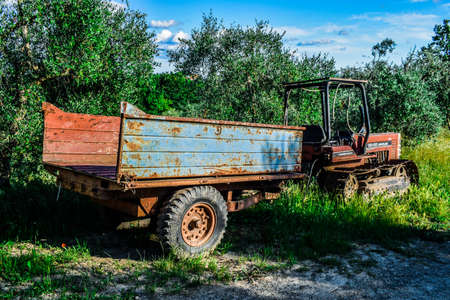 An old vehicle in the beautiful countryside of Peccioli in a sunny spring day near to olive trees, Valdera, Tuscany, Italyの写真素材