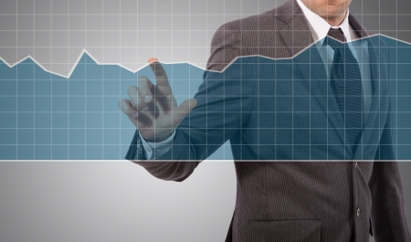 business man touching graph on screen, grey backgroundの写真素材