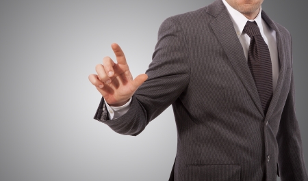 business man touching virtual screen, grey backgroundの写真素材