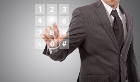 business man compose telephone number on screen, grey backgroundの写真素材