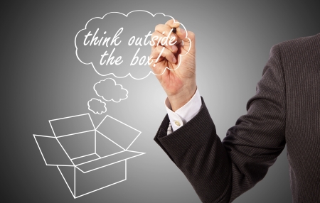 businessman write 'think outside the box' on glassの写真素材