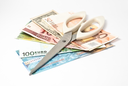 a closed scissors and several currency banknotesの写真素材