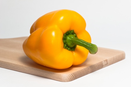 yellow pepper on a wooden cutting boardの写真素材