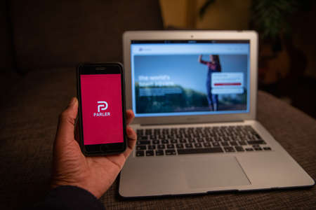 New York, United States, January 6th 2021: Close up of Parler app on the iPhone display standing in front of a macbook. Parler is a new social networking service very popular during the US electionsのeditorial素材