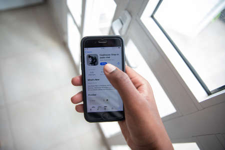 Smartphone with Clubhouse Drop-in audio chat shown on the screen. It's a new very popular social network based on voice where people come together to talkのeditorial素材