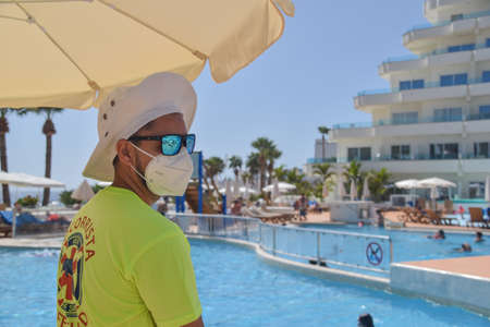 Tenerife, Spain: Portrait of lifeguard of the hotel who's wearing the mask to protect himself against the coronavirus pandemicのeditorial素材