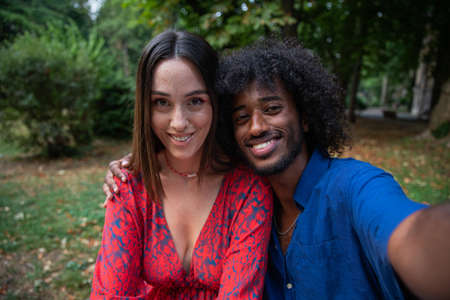 Group of girls of different ethnicities join hands and smile, friendship and integration between different womenの写真素材