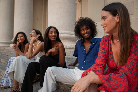 Group of girls of different ethnicities join hands and smile, friendship and integration between different womenの写真素材