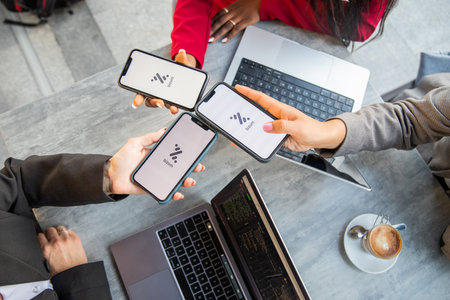 Tenerife, Spain, 13 January 2023: Three businesswomen during a meeting pay the bill with Bizum, a...