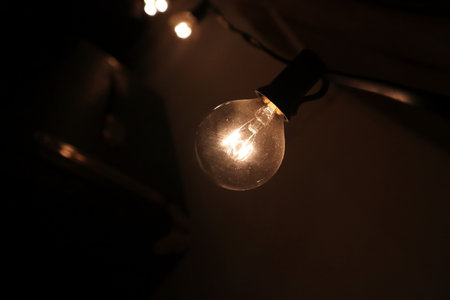 String lights bulb with a blurry suitcase in the backgroundの写真素材