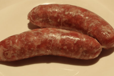 Two fresh Italian sausages on a sideの写真素材