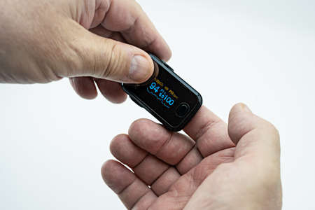 Measurement of oxygen saturation and pulse with a pulse oximeter on the finger.の写真素材