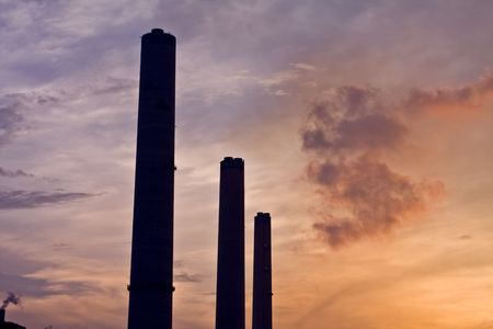 Powerstation chimmneys at sunset with smoke