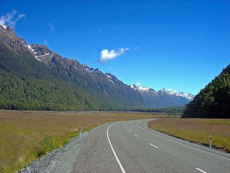 A New Zealand road disappearing into the distance backed by a snow capped South Island mountain range.の写真素材