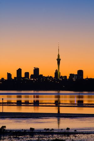 Auckland City in silhouette at sunrise viewed across the water, Auckland, New Zealandの写真素材