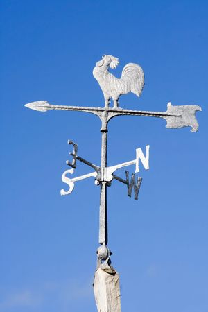 An old fashioned steel weather vane isolated against a bright blue skyの写真素材