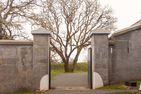 A view of the entrance to a park with a tree in the background