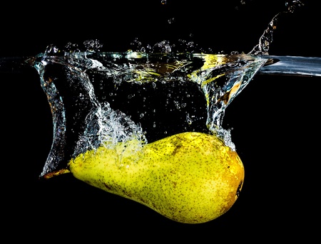 fresh pear dropping into waterの写真素材