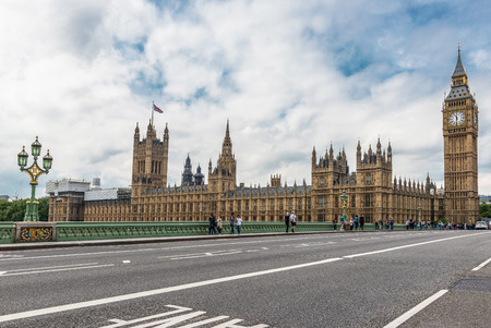 Tourists cross the Westminster Bridge in front of the Big Ben and Houses of Parliamentのeditorial素材