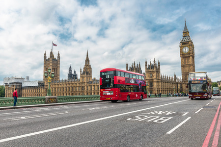 Buses and tourists cross the Westminster Bridge in front of the Big Ben and Houses of Parliamentのeditorial素材