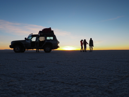Silhouette scene during sunrise in the Salar de Uyuni, Boliviaの写真素材