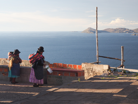 Bolivian women in traditional dress at Lake Titicacaの写真素材