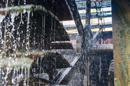 Water wheel made of metal and wood in use, carries waterの写真素材