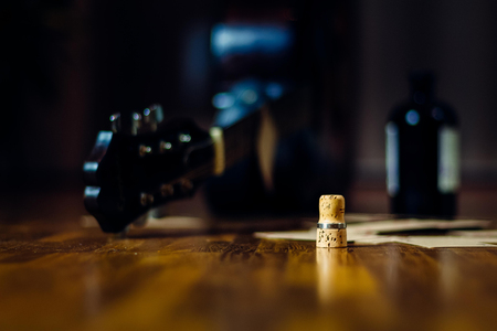 Liquor bottle, playing cards and guitar as a concept for alcoholism, addiction, rock'n'roll and ramshackle lifestyle.の写真素材