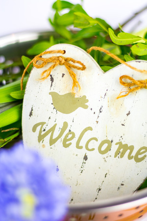 Bouquet of hyacinths in a copper bowl with a welcome sign.の写真素材