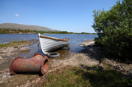 An old boat with a strange anchor, in a quiet lake in Irelandの写真素材