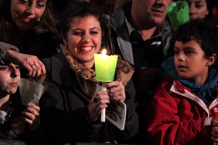 29th March 2013, Colosseum Square, Rome: People attending the Stations of the Cross chaired by the Pope Francis I around the coliseum on Good Friday. People are receiving candles and booklets of prayers. A girl lights her candle.のeditorial素材